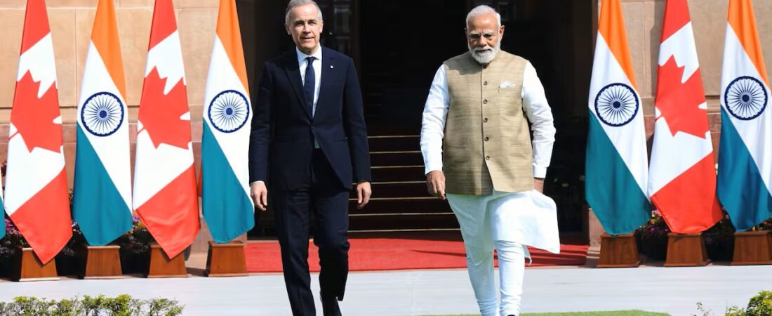 Piyush Goyal caminha ao lado de Mark Carney, entre bandeiras do Canadá e da Índia, durante uma visita oficial.